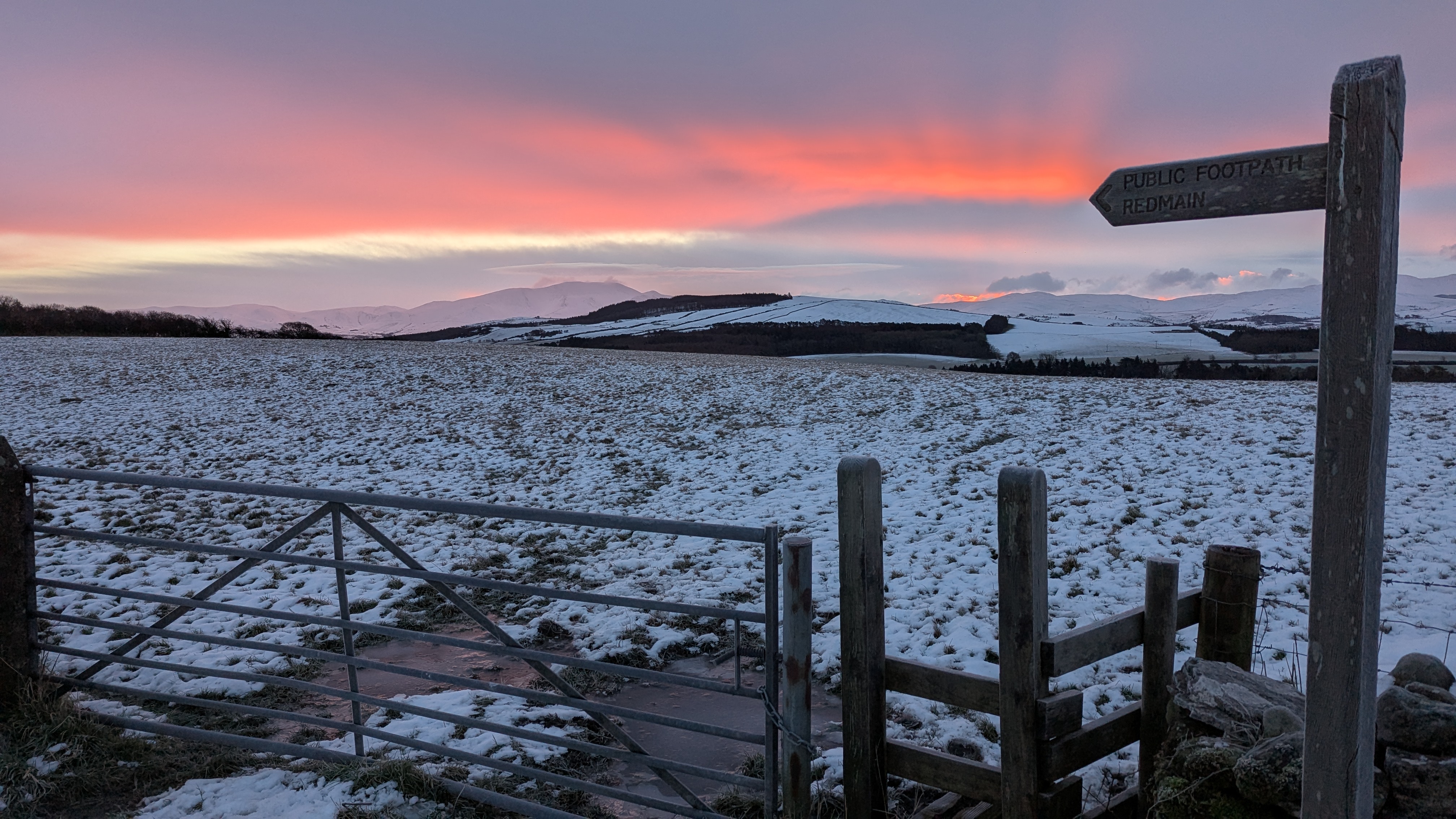 Pink sunrise over snow-dusted fields near Keswick